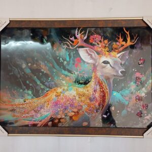 A deer with antlers stands in a forest with a stream in